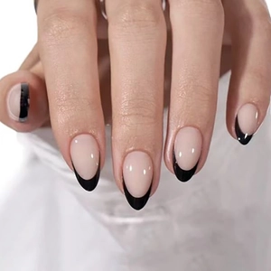 Short oval French press-on nails with nude base and black tips for an elegant minimalist look