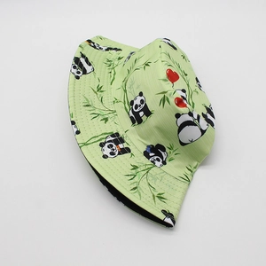 Détail d'un chapeau bob vert clair avec des motifs mignons de panda et de bambou