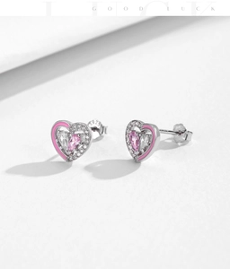 Macro shot of S925 silver heart earrings with pink enamel and pear-shaped crystals