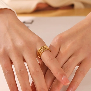Minimalist triple-layer golden stainless steel open ring shown on a model's hand