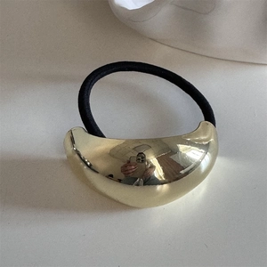 Detail of minimalist elastic hair tie with polished gold crescent metal decoration