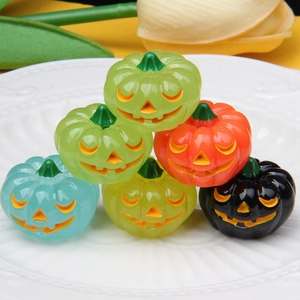 Miniature colorful resin pumpkins on white ceramic plate for Halloween decoration