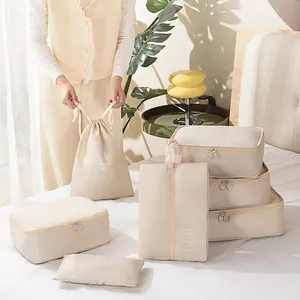 Beige wasserdichte Reise-Organizer-Taschen auf Bett für Koffer-Verpackung
