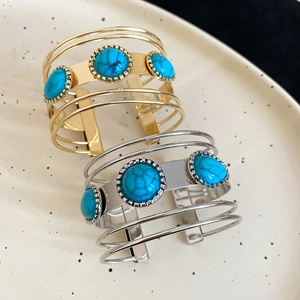 Close-up of bohemian cuff bracelet with turquoise stones and vintage metal patterns