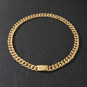 Macro detail of golden Cuban link necklace featuring a unique hammered texture buckle clasp