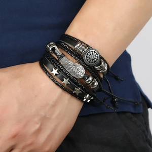 Detail of multilayer leather bracelet set with silver feather charm and star studs