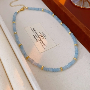 Detailed shot of blue Shoushan stone beads and gold metal spacers on a heart necklace