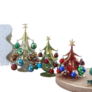 Three-piece set of colorful metallic Christmas tree ornaments on a round wooden tray