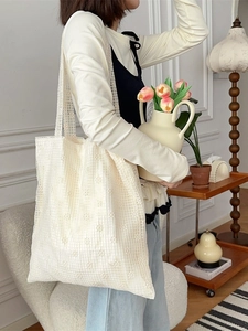 Minimalist white lace crochet tote bag with large capacity shown on a model in a home setting