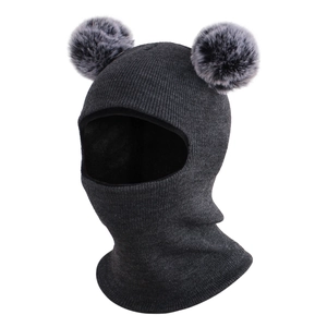 Detail of dark grey knitted baby balaclava hat with large soft faux fur pom-poms