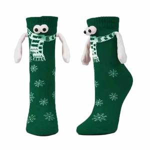 Close-up of 3D Christmas green socks with cartoon eyes, scarf, and snowflake pattern