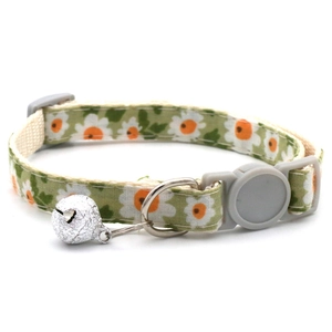 Detail of green daisy pattern pet collar with plastic buckle, metal bell and D-ring