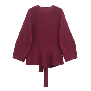 Detail of burgundy knit sweater showing ruffled hem, wide cuffs and matching waist tie