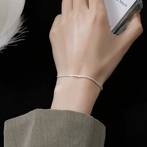 Minimalist 925 sterling silver shimmering chain bracelet shown on woman's wrist