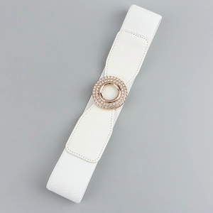 Detail of white wide elastic waist belt featuring a round buckle with sparkling rhinestones