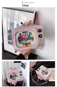 Pink TV-shaped crossbody bag featuring transparent window and vintage No Signal test pattern