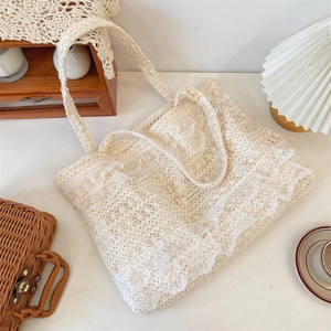 Detail of floral lace tote bag featuring ruffled edges and vintage Sozakka brand label
