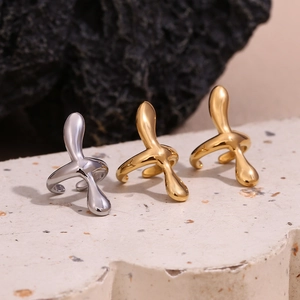 Macro shot of liquid metal earrings in gold and silver finish on textured stone