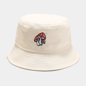 Détail de la broderie de trois champignons rouges sur un chapeau bob en coton crème