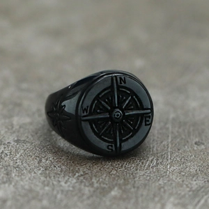 Macro detail of vintage black stainless steel ring showing compass engraving and star patterns