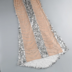 Detailed view of silver sequins and cascading bead chains on a nude mesh evening dress