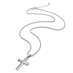 Détail macro du pendentif croix argenté vintage avec texture diagonale en acier inoxydable