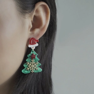 Festive Christmas tree and red hat earrings worn by model for a stylish holiday look