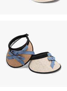 Detail of straw sun hats featuring blue denim bows and contrast black fabric edging