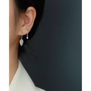 Close-up of S925 sterling silver hoop earrings with geometric diamond-textured pendants