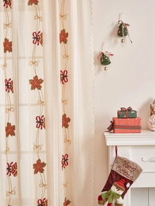 Details von weihnachtlichen Spitzenvorhängen mit roter Stickerei und dekorativen Bögen