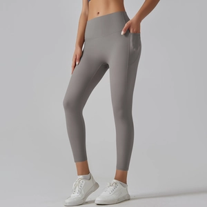Detail view of high waisted grey yoga leggings with functional side pocket on the leg