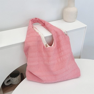 Detail of pink pleated fabric tote bag showing textured material and interior lining