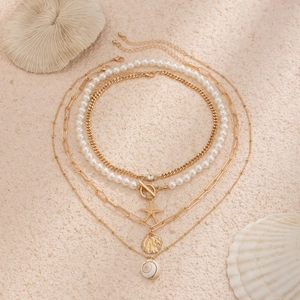 Layered beach necklace set with starfish and shell pendants in gold finish