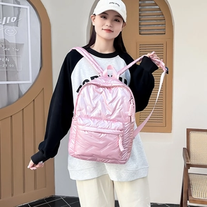 Rosafarbener Metallic-Stepprucksack am Model vor einem stilvollen Ladenhintergrund