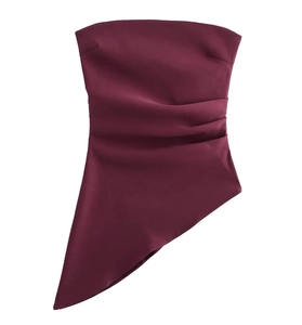 Detail of wine red strapless top featuring ruched satin fabric and asymmetrical hemline