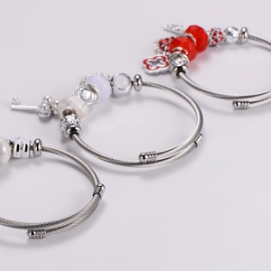 Three silver stainless steel cable bracelets with pearl and heart pendant charms