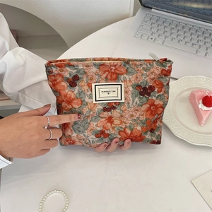 Detail of floral corduroy cosmetic bag with PLEASANT TIME label and zipper closure