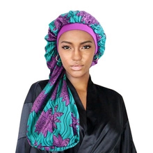 Detail of African floral satin sleep bonnet with double-layered lace trim in purple and green