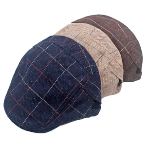 Close-up of wool tweed newsboy caps in plaid and herringbone patterns with metal eyelets