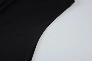 Gros plan sur la texture du tricot noir et les coutures détaillées de la robe moulante