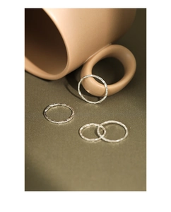 Close-up of four minimalist S925 sterling silver rings with hammered texture for women