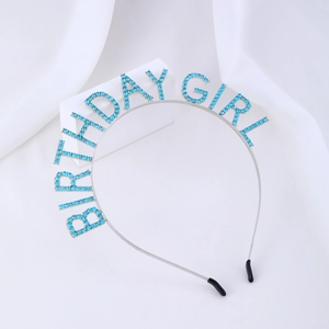 Detail of metal Birthday Girl headband with blue rhinestones on a white background