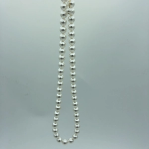 Macro detail of high-luster round white pearls on a high-quality 14k gold chain necklace