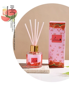 Macro shot of watermelon scented reed diffuser with pink sticks and elegant glass bottle