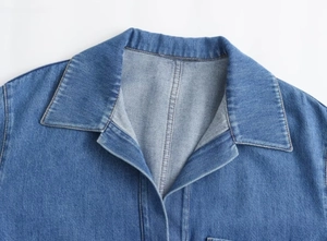 Detailansicht eines blauen Denim-Hemdkragens mit sauberen Nähten und hochwertiger Textur