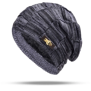 Dettaglio del berretto in maglia grigio scuro con fodera in pile e patch logo in pelle