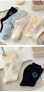 Close-up of ribbed cotton crew socks with colorful smiling face embroidery details