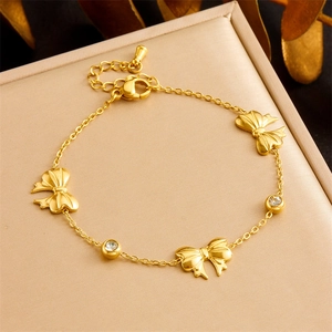 Gold plated stainless steel jewelry set featuring bow charms and zircon on gift box