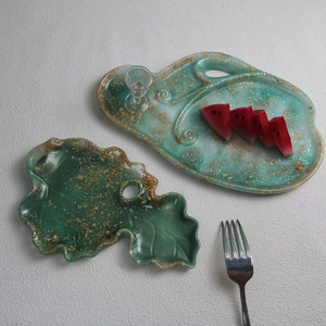 Detailed view of leaf-shaped epoxy resin trays with embedded gold foil and green glitter