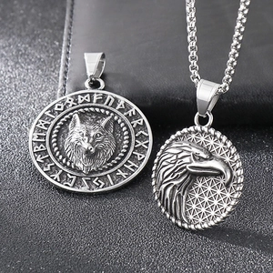 Macro view of Nordic Viking wolf and eagle embossed pendants in antique silver finish